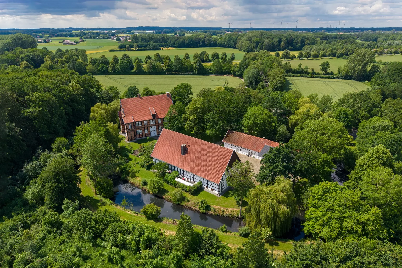 Haus Aussel Showroom UniversalRooms Luftaufnahme Rheda-Wiedenbrück — historisches Fachwerkensemble mit Wassergraben in westfälischer Landschaft